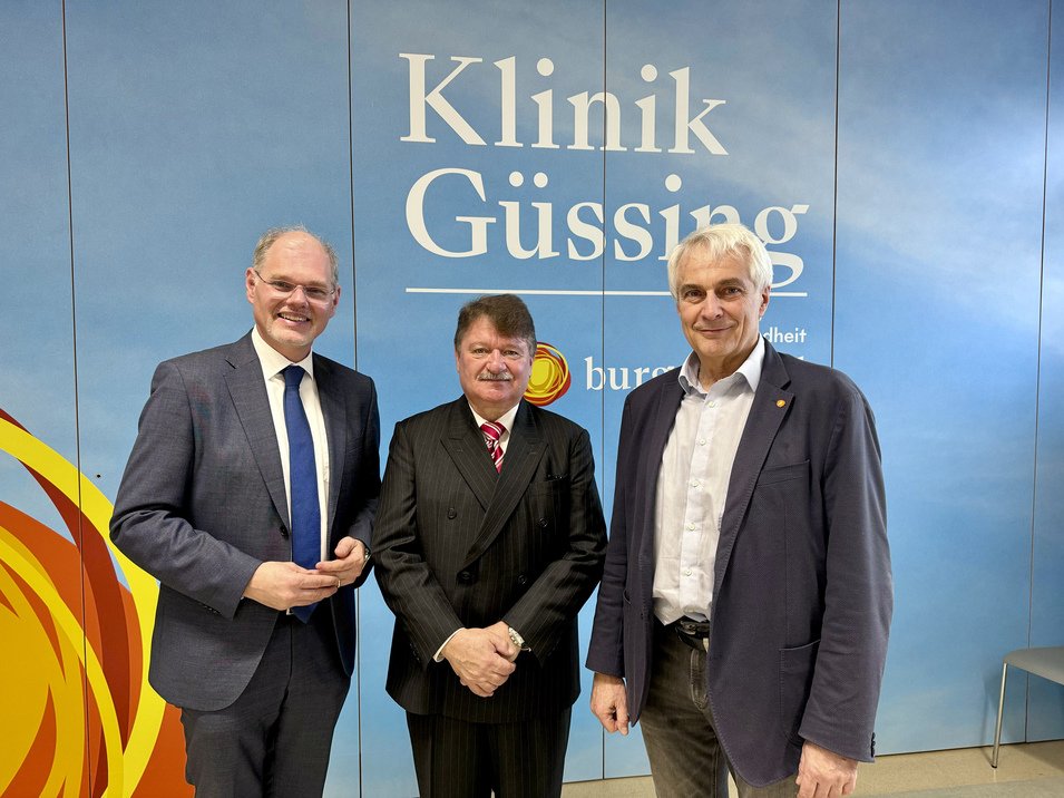 Foto: Gesundheit Burgenland Mag. Franz Öller, Primar Dr. Gerhard Puhr, Univ.-Prof. Dr. Stephan Kriwanek stehen vor dem Logo der Klinik Güssing