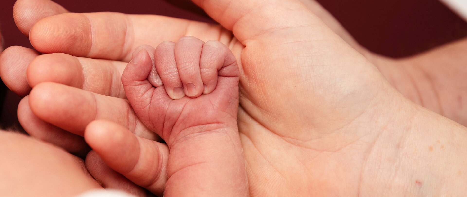 Foto: Hero Media Große Hände halten Babyhände