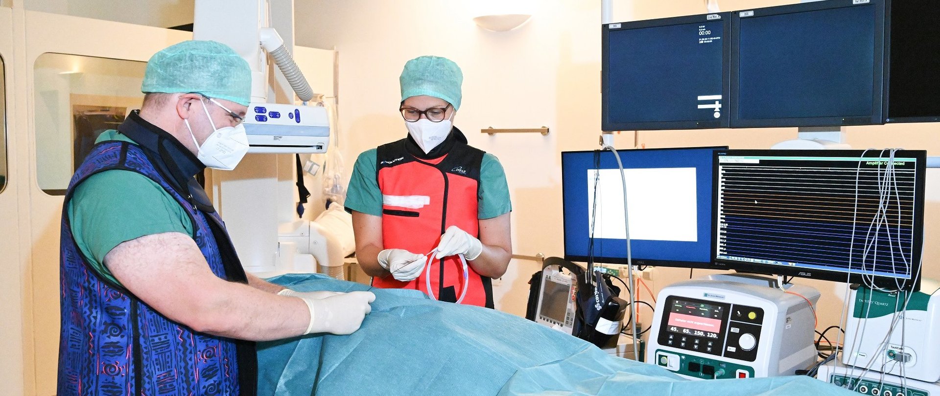 Arzt und Pflegekraft während einer Gefäßuntersuchung mit Angiografieanlage